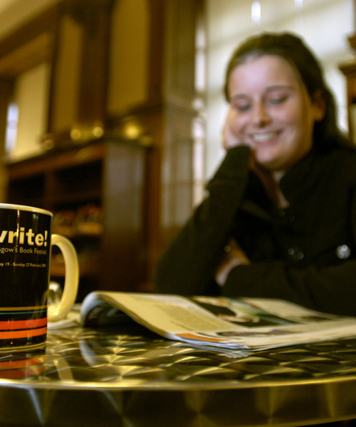 Woman reading Aye Write brochure in library