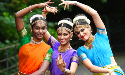 Three women in traditional dress art Glasgow Mela