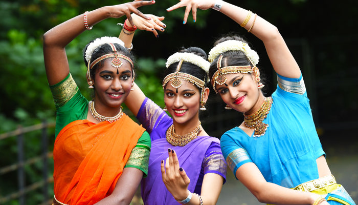 Three dancers in traditional dress art Glasgow Mela