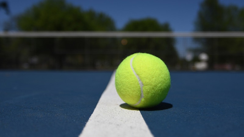 tennis ball on blue court