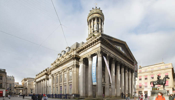 large museum in the middle of a city square. there are grand pillars around the building