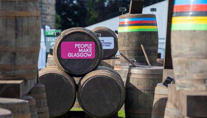 A barrel which is part of the BMX course at Glasgow Green for the 2023 UCI Cycling World Championships. The barrel has a pink People Make Glasgow sign on it.