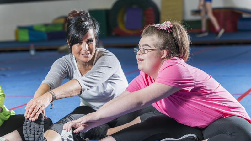 disabled girl stretching with her dance teacher