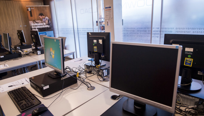 A bank of computers on white desks.