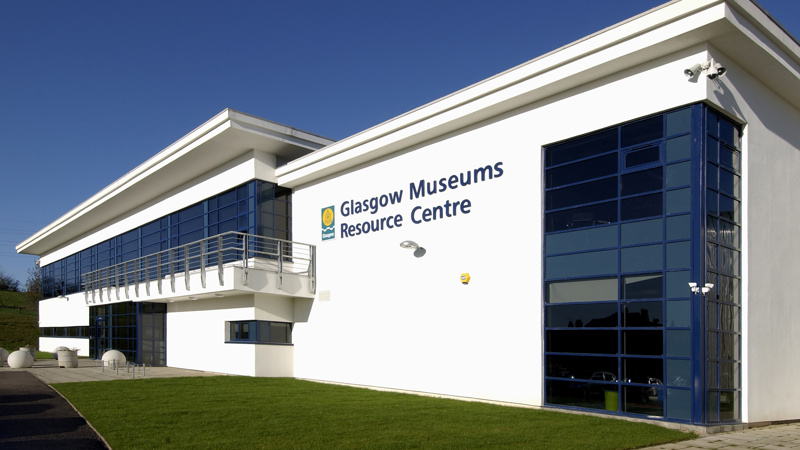 The outside of the Glasgow Museums Resource Centre. The building is a large, white warehouse. 