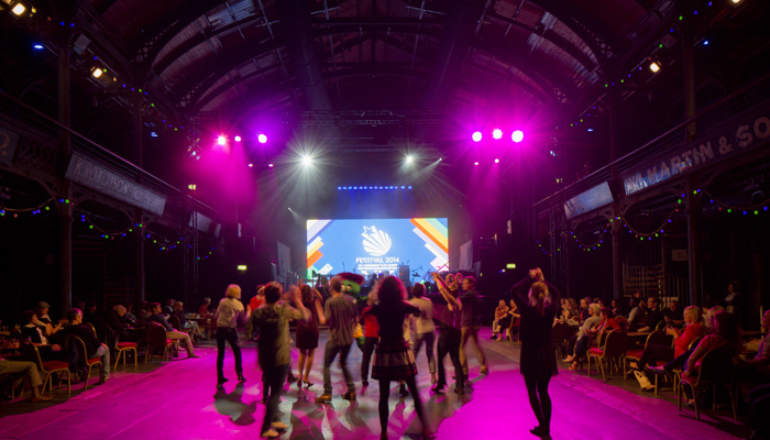 Performers dancing in front of crowds in the Old Fruitmarket in Glasgow as part of Festival 2014 at the Commonwealth Games.