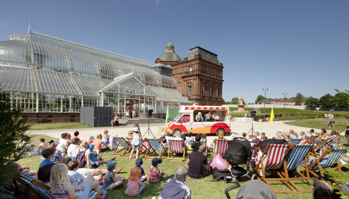 People sitting in deck chairs and enjoying the sun in front of the People's Palace in Glasgow Green at the fan zone for the 2014 Commonwealth Games.