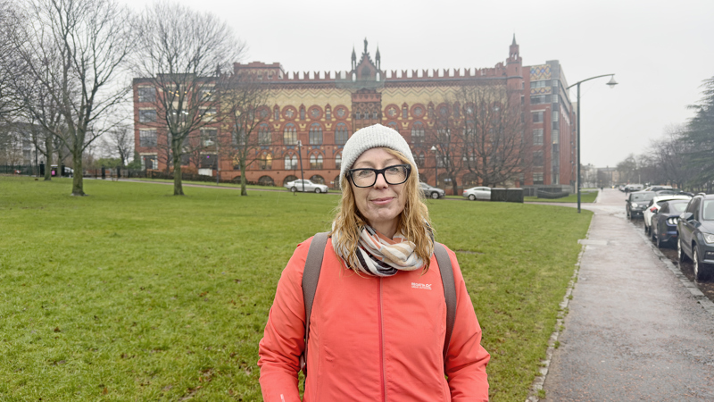 Photograph of Ingrid Shearer standing in front of Templeton's Carpet Factory building