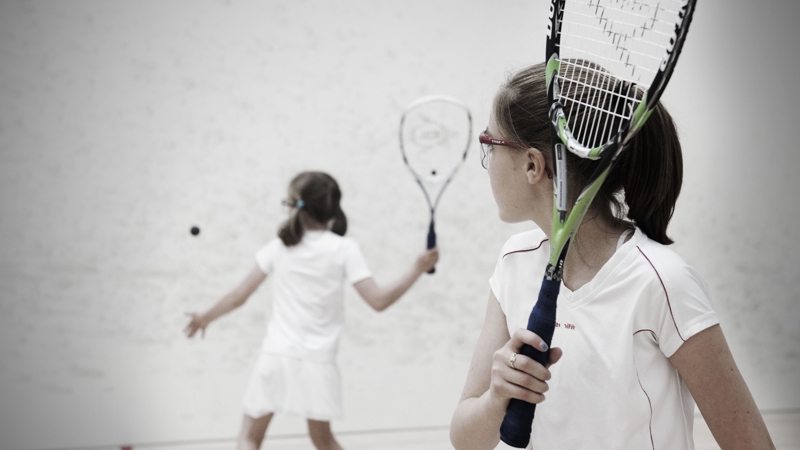 Two young people playing squash