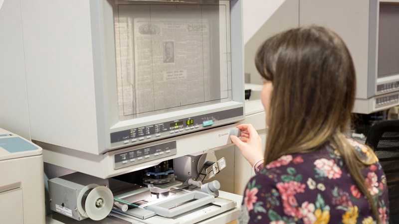 Person sits at newspaper archive