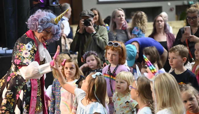 A group of young people watching a performer at Merchant Square during the 2023 UCI Cycling World Championships.