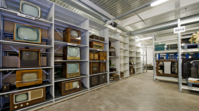 A collection of vintage TVs on shelves in one of the storage rooms at GMRC