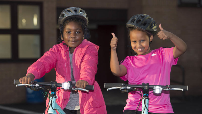 Two young children on bikes smiling