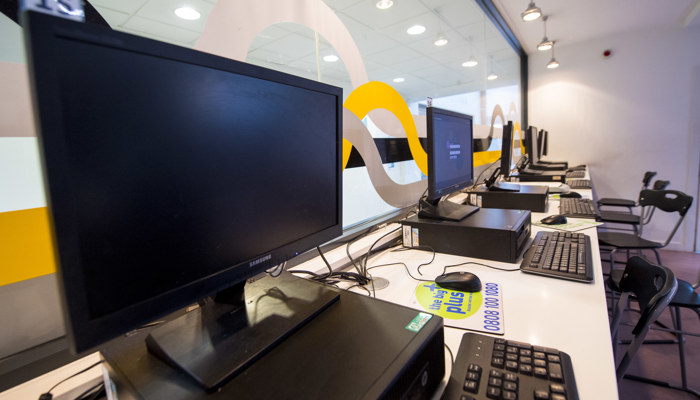 A row of black PC's on a white table