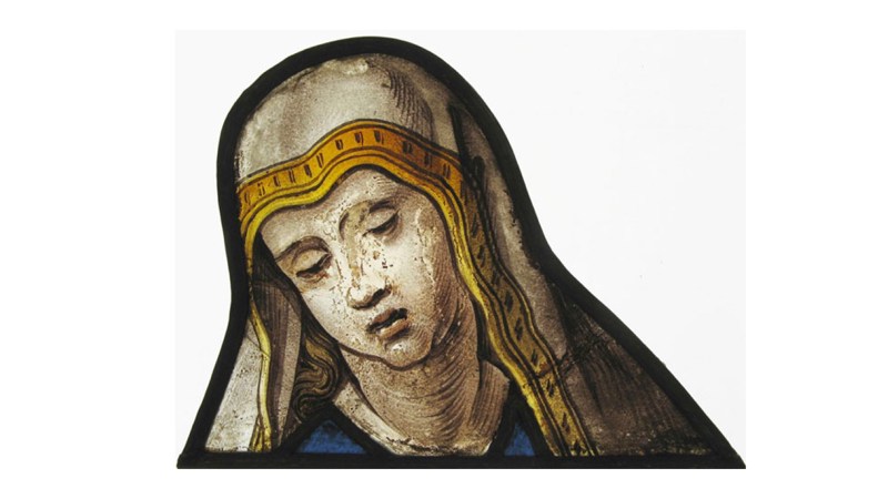 fragment of stained glass showing a shrouded figure in a gold and white shroud