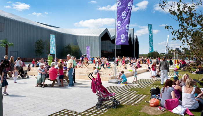 lots of people and families gathering outside a museum on a summers day