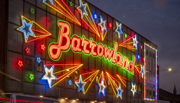 The Barrowlands sign lit up in multi-coloured lights at night time.