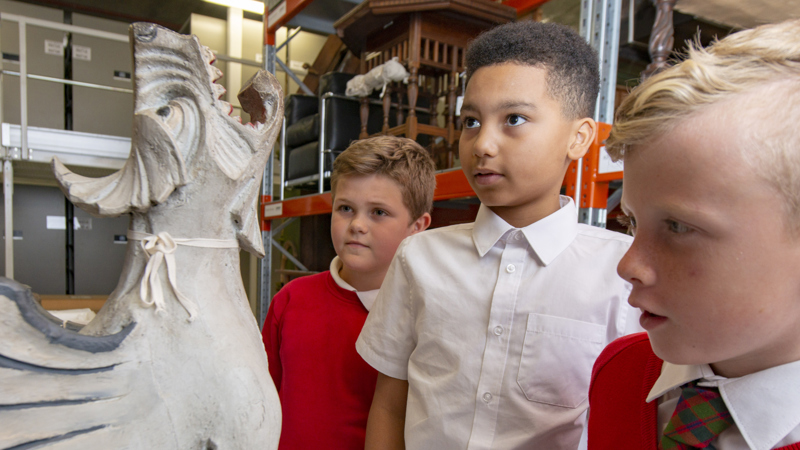 Photograph showing young people looking at a sculpture in a museum store