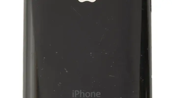 a photograph of an original iPhone on a white background. The apple logo is visible on the rear.