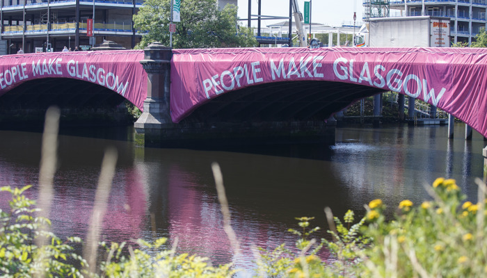 A bridge over the River Clyde in Glasgow which is covered in People Make Glasgow signage.