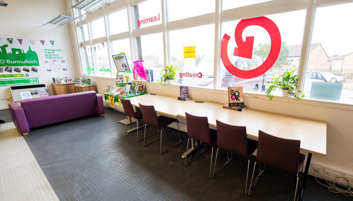 A long rectangular table at the window of Barmulloch Library with 5 chairs