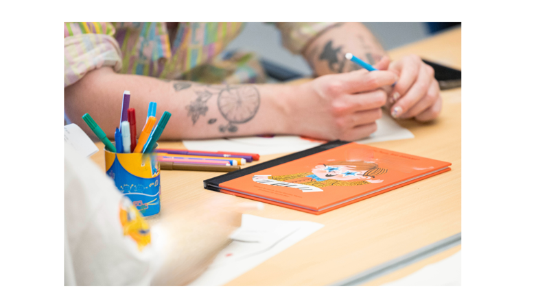 close up of people sitting at a desk in a learning workshop enviroment