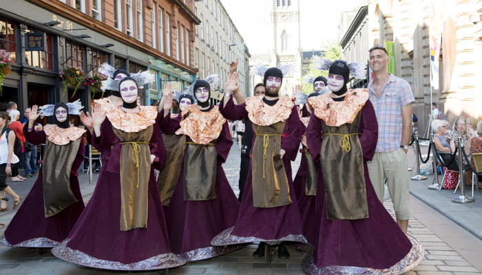 Street performers in costumes in the Merchant City during Festival 2014 as part of the Commonwealth Games in Glasgow.