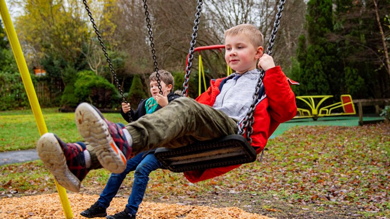 Young boy in a playground on a swing