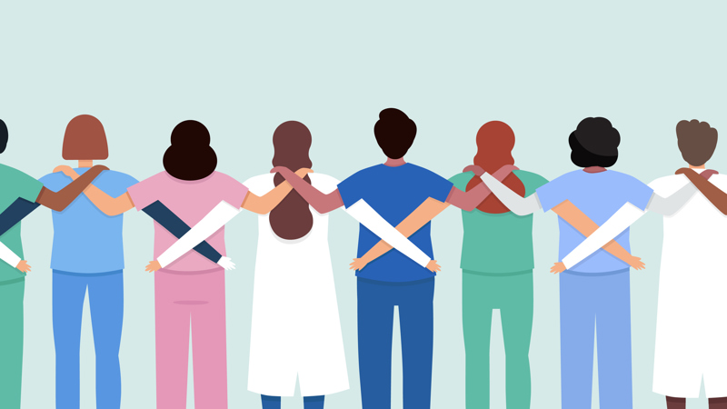 A row of people with their backs to the viewer - all supporting each other with their arms around each other. They are wearing medical outfits.