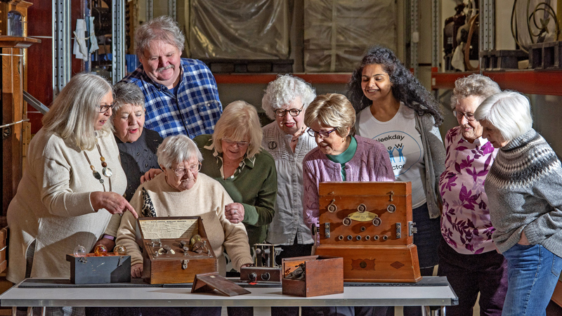 Photograph showing a group of people looking at and discussing a handling box.