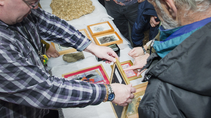 Photograph showing a selection of picture frames holding images, out for sharing in a community centre.