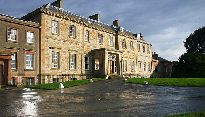 photograph of n old 2 storey building in blonde sandstone