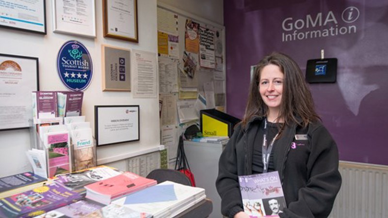 Photograph showing a museum gallery assistant with some sensory kits.