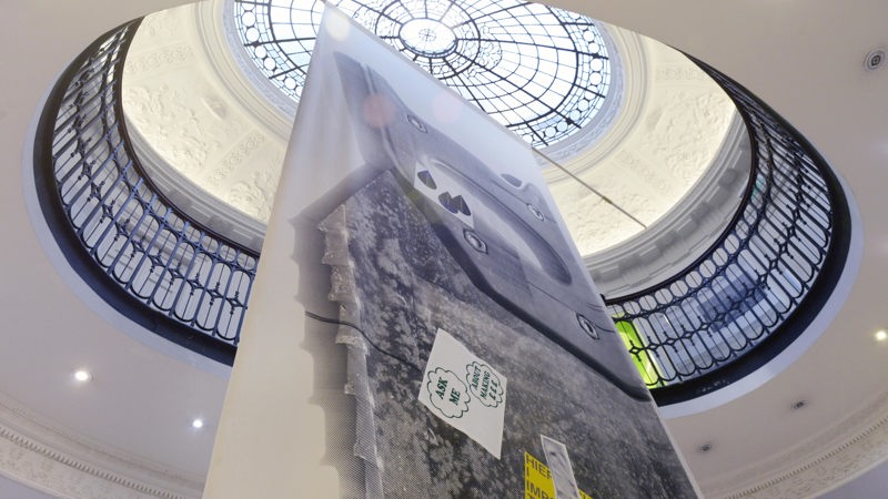 A vast banner, pictured from below, hangs in GoMA's grand main entrance