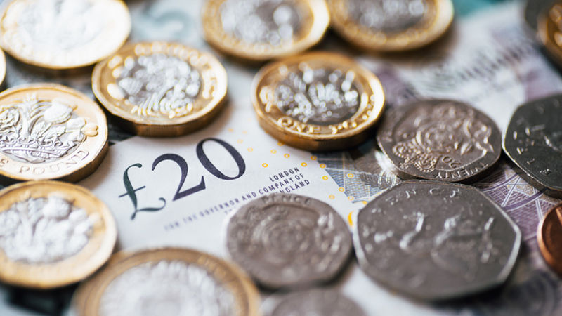 A close up of coins and notes in Pound Sterling.