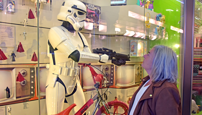 Photograph showing Susan Morrison looking at a Storm Trooper costume on display in Riverside Museum