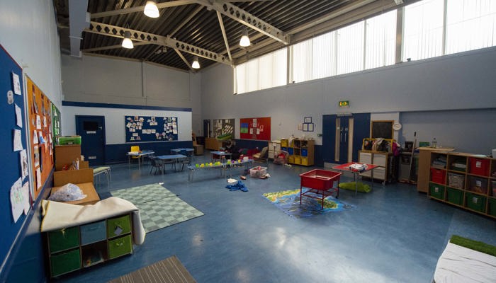 a large room with a tall ceiling equipped for children with toys