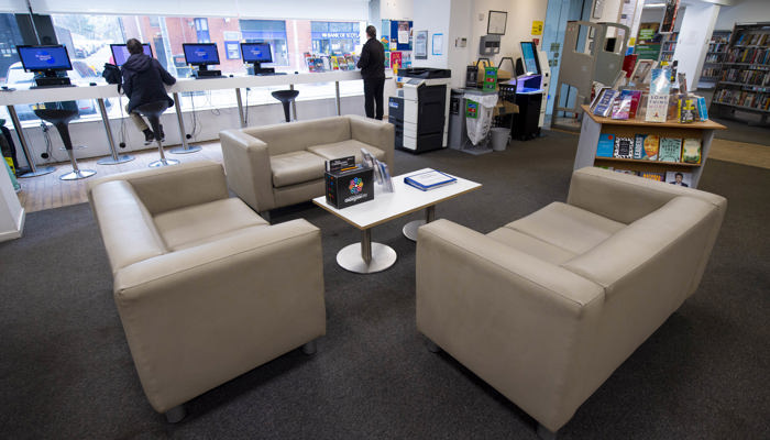 A view of the sofa area in Anniesland Library. There are three sofas facing each other and in the background you can see the PC's at the window and a stand alone bookshelf. 