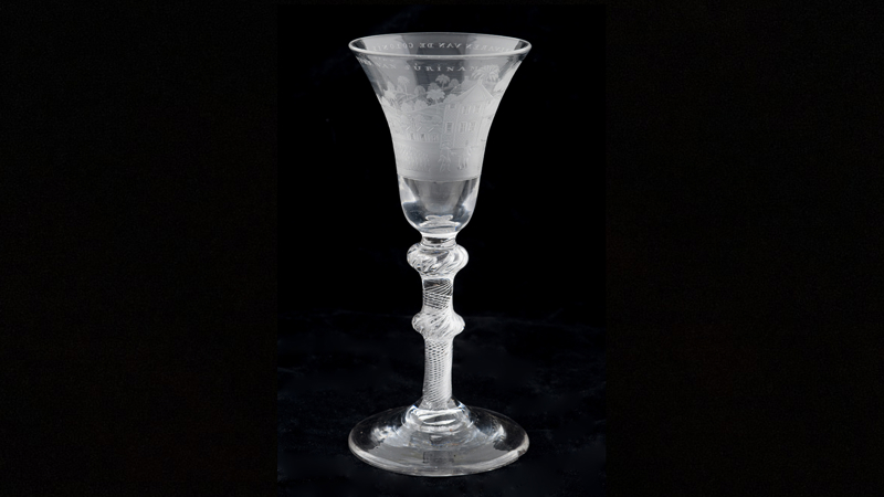 a wine glass with an engraving of a Suriname plantation