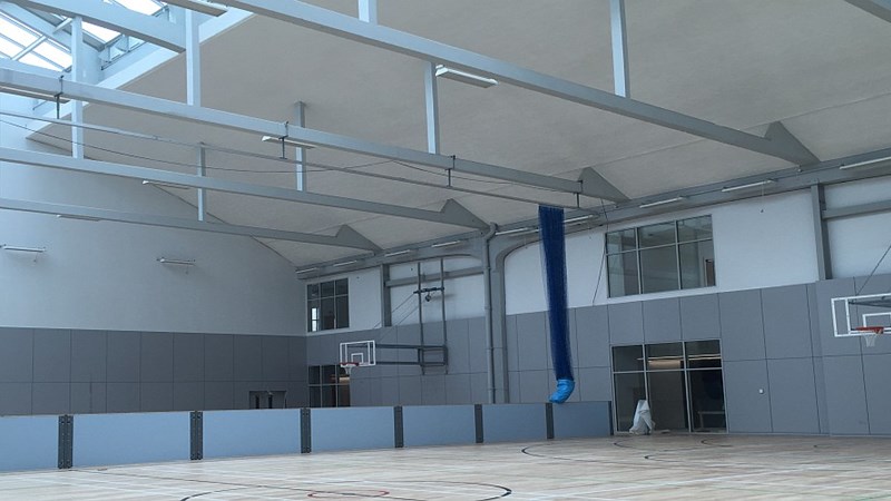 One of the multipurpose sports halls at Kelvin Hall. There are basketball nets on the wall and room dividers to an adjacent sports hall. 