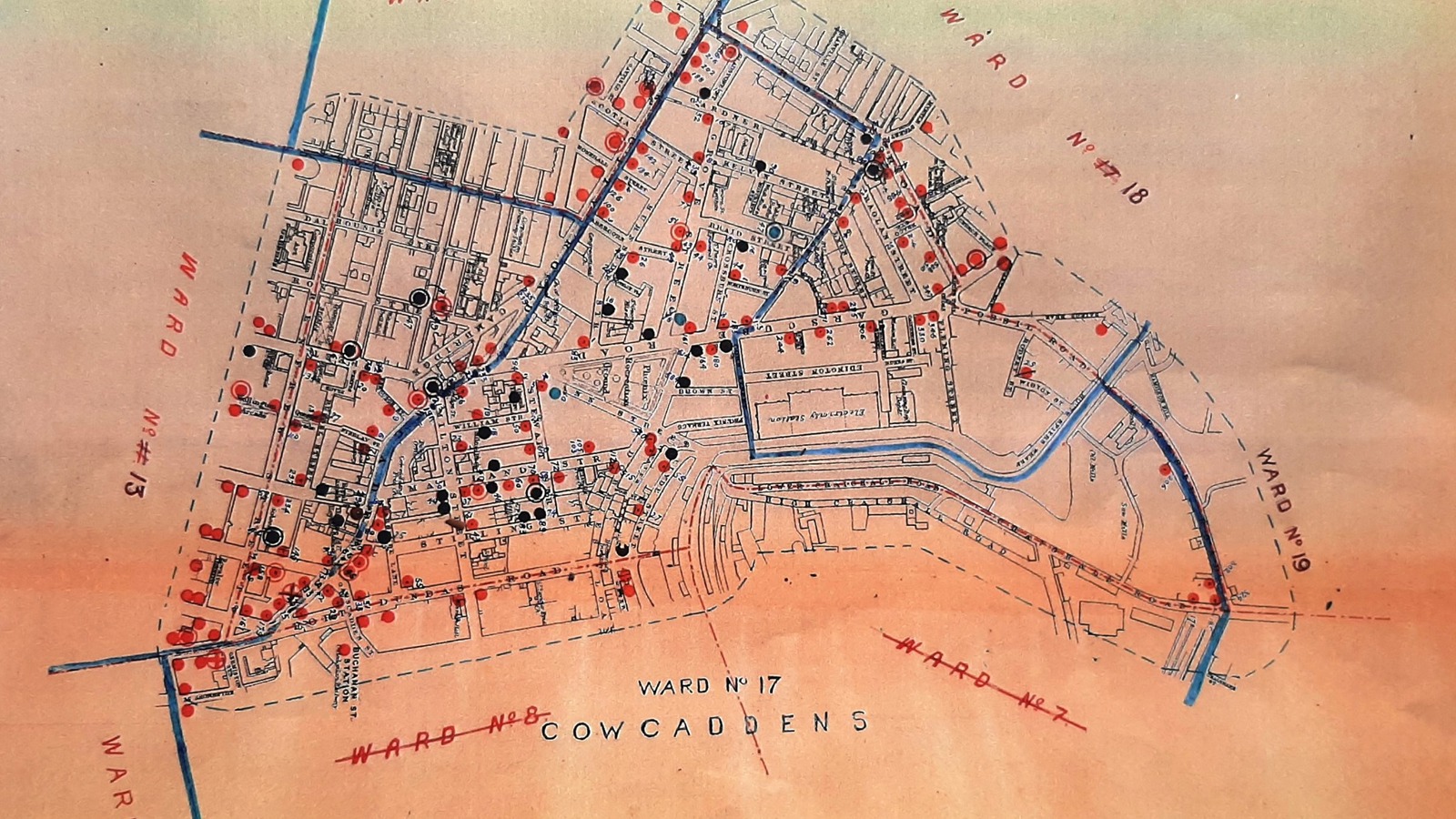 A map of pubs in Glasgow printed on an orange piece of paper and pub markers in red, black and blue.