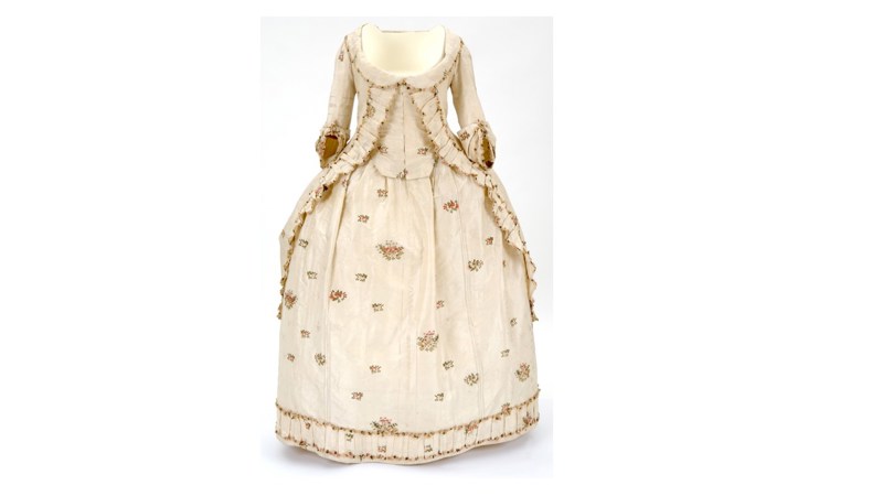 an image of a long cream dress with brown spotty patterning on the front.