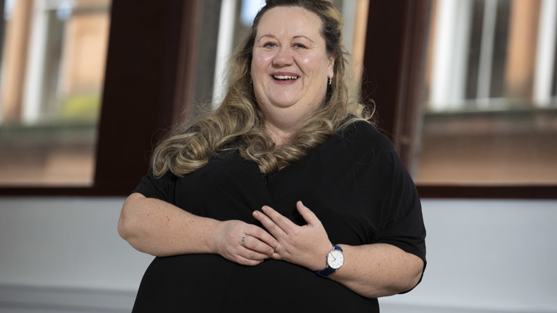 A head and shoulders portrait of a smiling woman