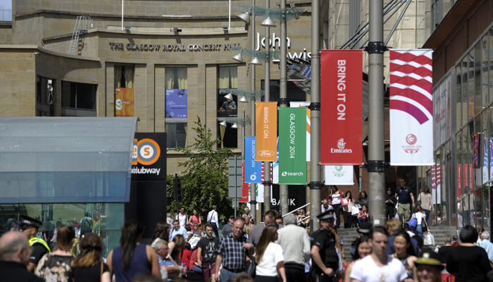 Crowds of people walking up Buchanan Street during the 2014 Commonwealth Games with the Glasgow Royal Concert Hall in the distance.