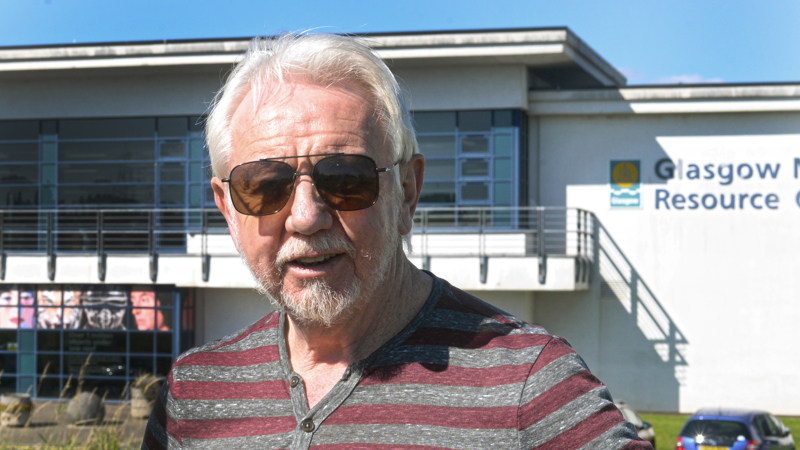 Photograph of the writer Chris Dolan standing outside in front of Glasgow Museums Resource Centre