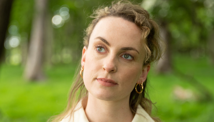 Irish musician Niamh Bury outside next to some trees and greenery