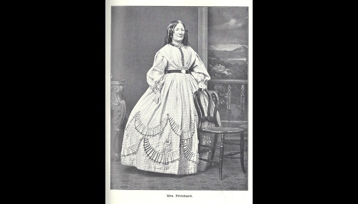 Photograph of a Victorian lady. She is wearing a dress with a large skirt.