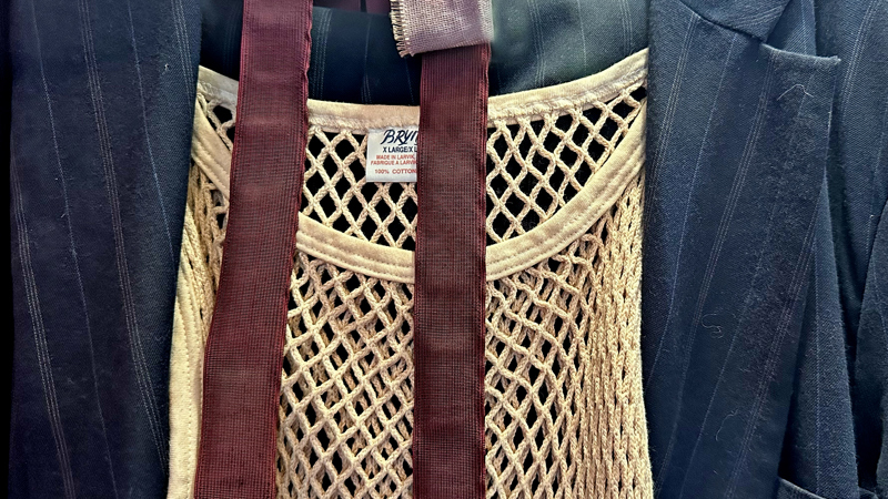 Photograph showing a close-up of Rab C Nesbit’s string vest, braces and suit jacket